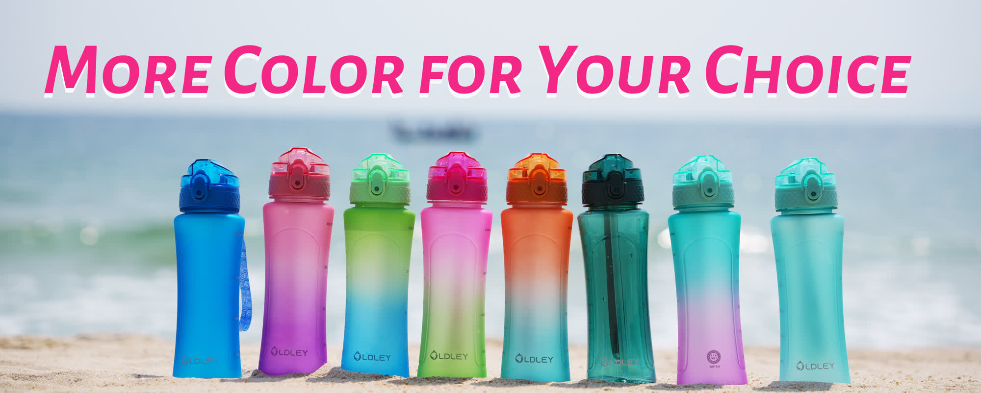 eight colorful gradient water bottles in blue purple green pink orange teal standing on sandy beach with ocean waves in background
