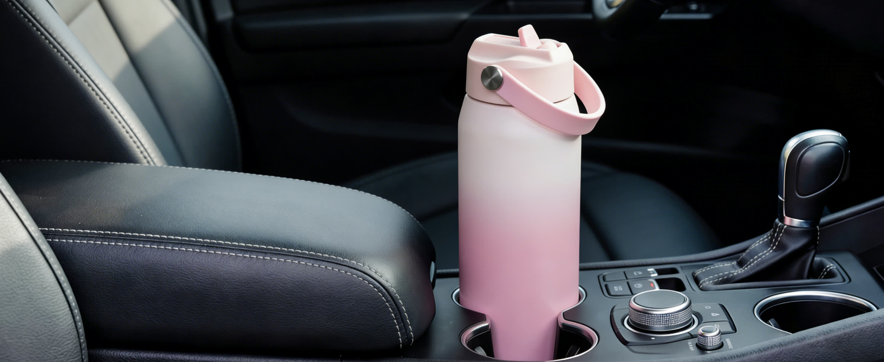 pink gradient water bottle with strap in car cupholder
